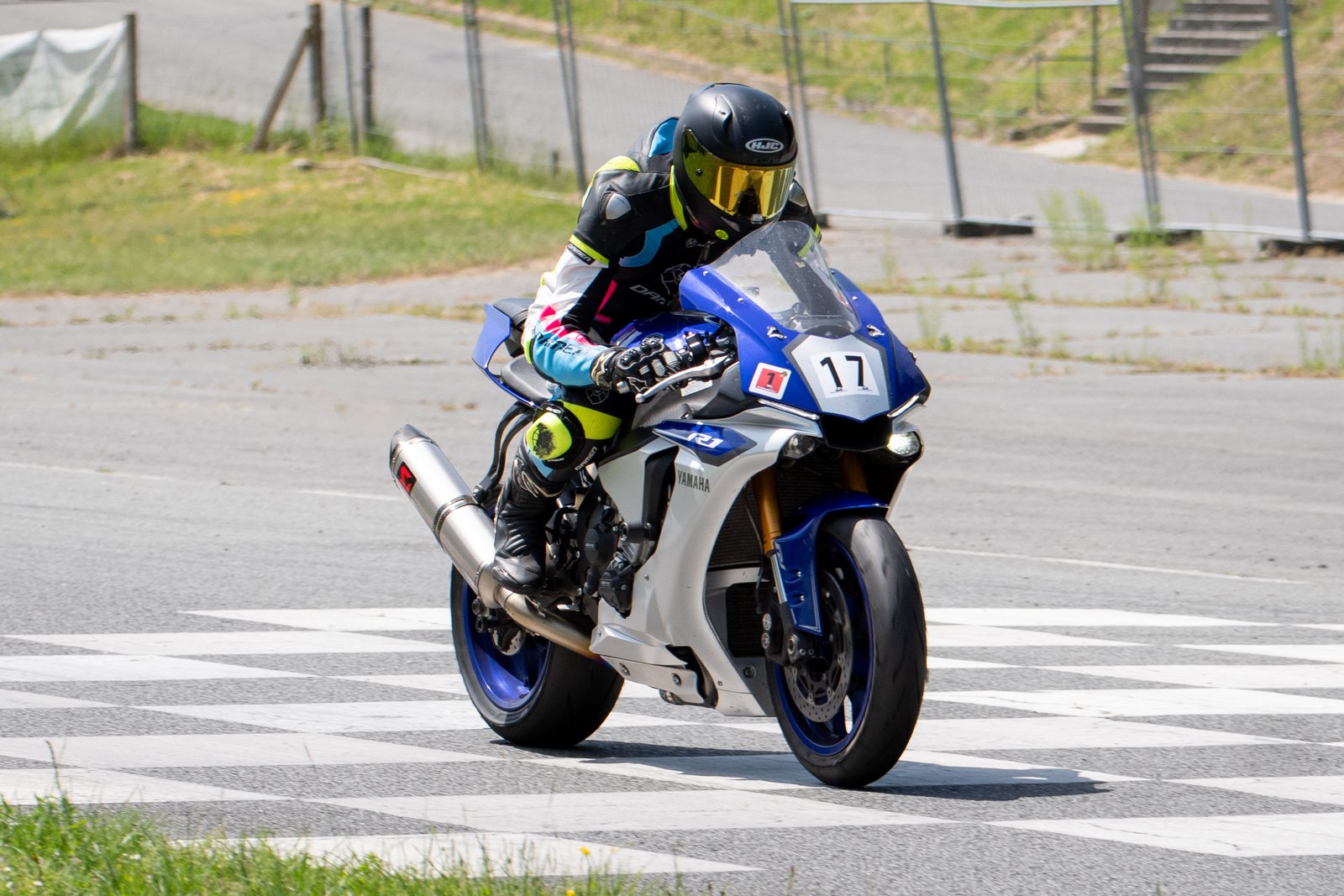 Motorcoureur versnelt weg met opkomend voorwiel op het circuit