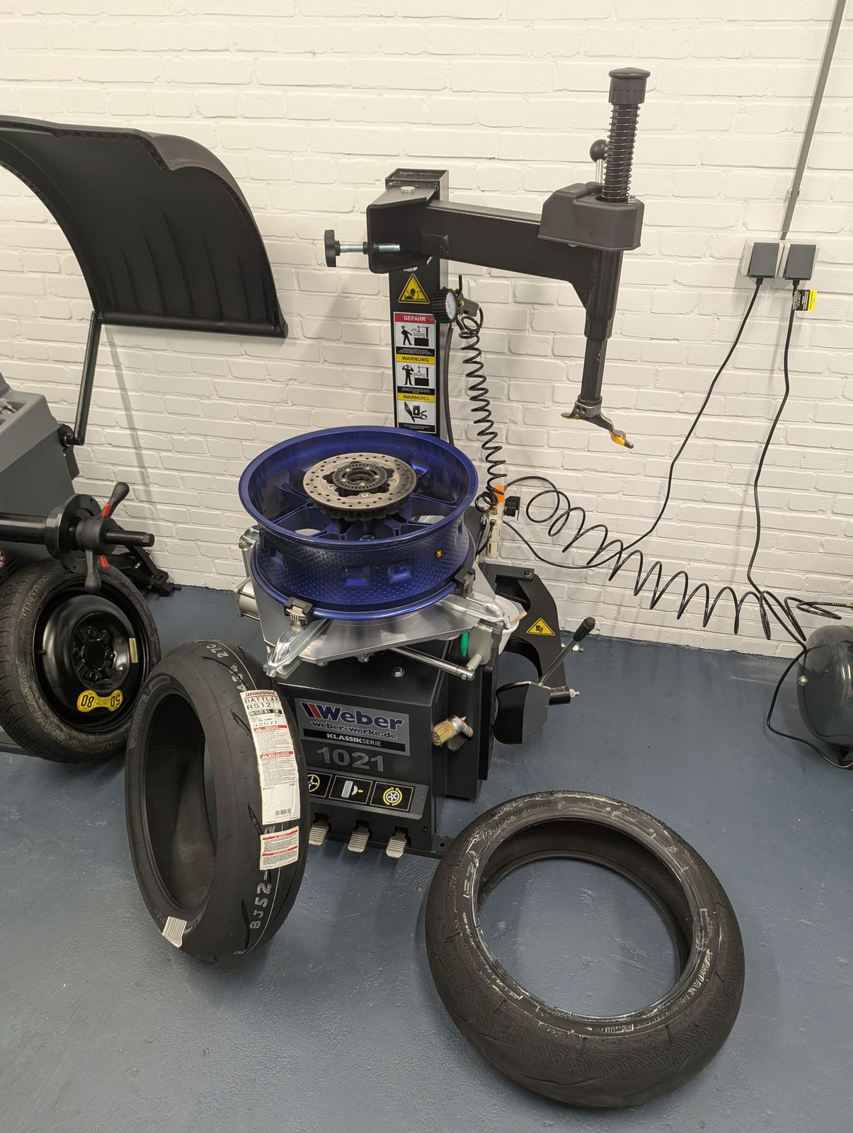 Bandenwisselmachine met een motorwiel in de werkplaats